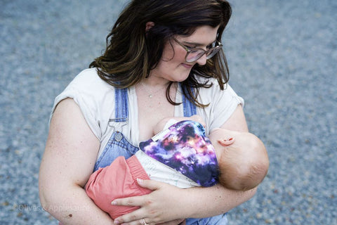 mama holding sleeping baby wearing supernova baby bib