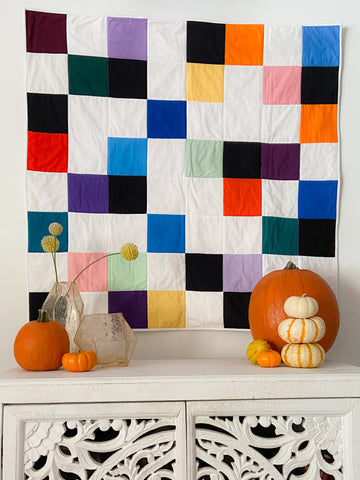 colorful wall quilt styled with pumpkins
