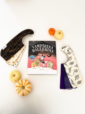 halloween themed bibs shown with children's halloween themed book and pumpkins