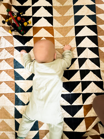 baby doing tummy time on handmade quilt