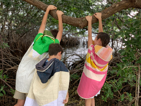 kids hanging on a tree branch with quilts acting like wild things