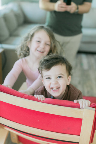 toddlers on rocking chair smiling