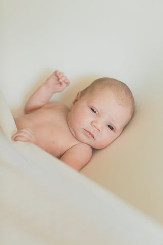 naked newborn baby with eyes open
