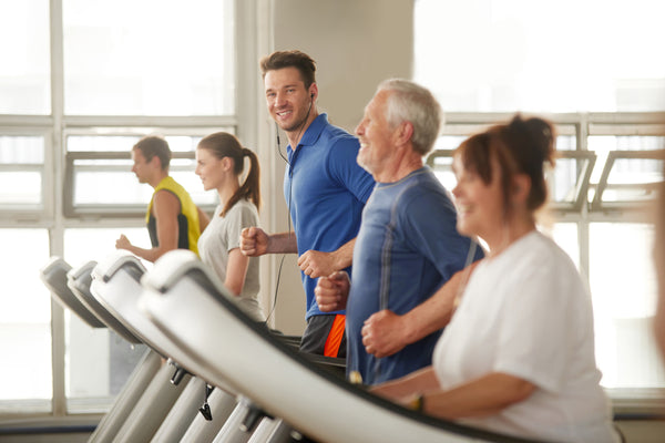 man on treadmill exercising along older man and middle-aged woman