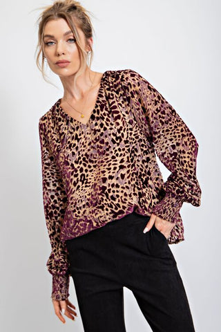 Woman wearing brown animal print top with black trousers
