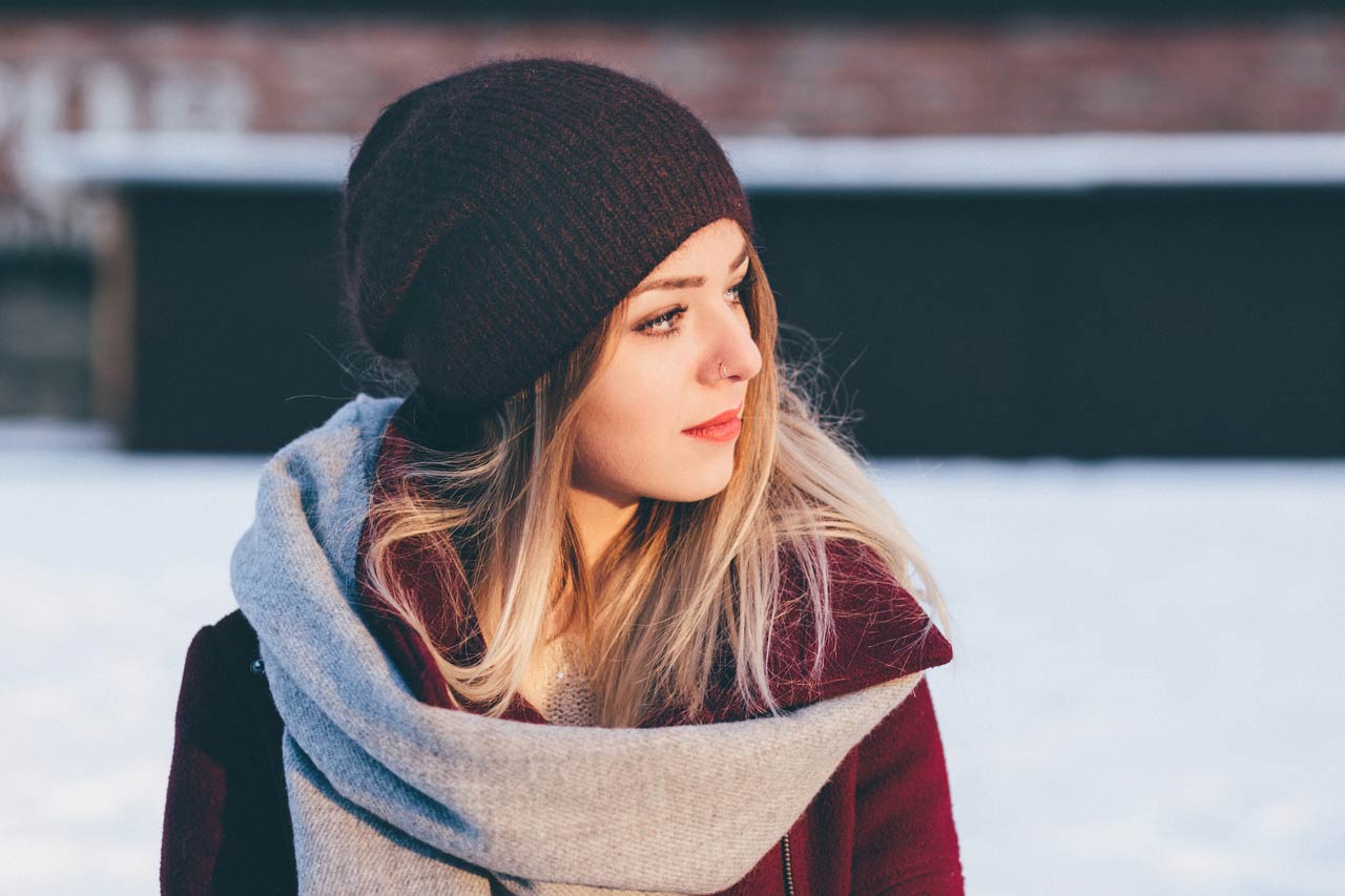Woman looking out at snow in winter clothes