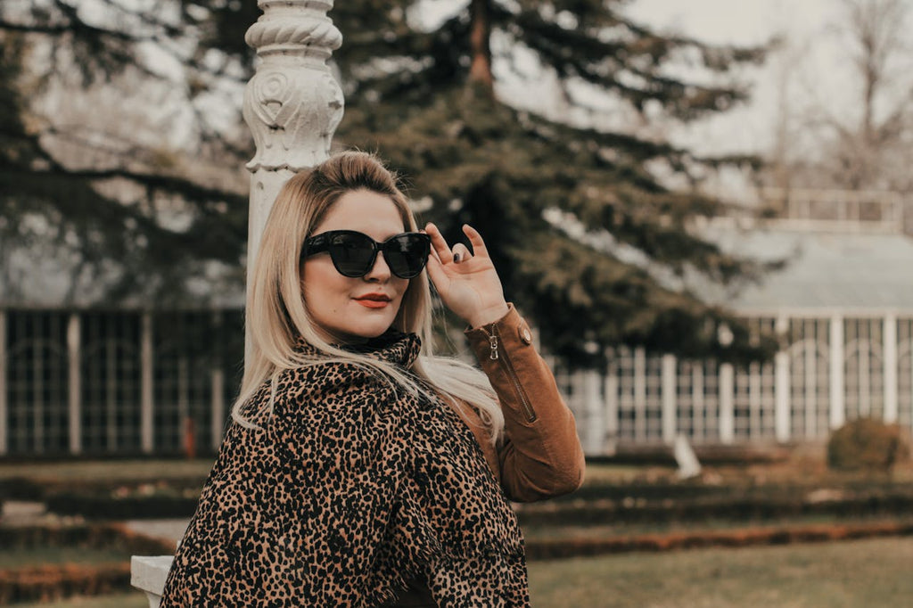 Blonde woman wearing sunglasses and animal print jacket