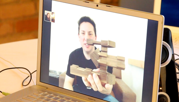 man on screen video conferencing holding assembled Empathy Toy to camera