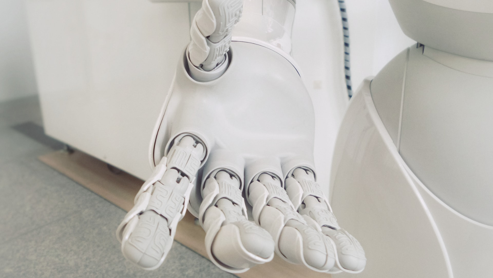 An upturned white robot hand reaches toward the camera.