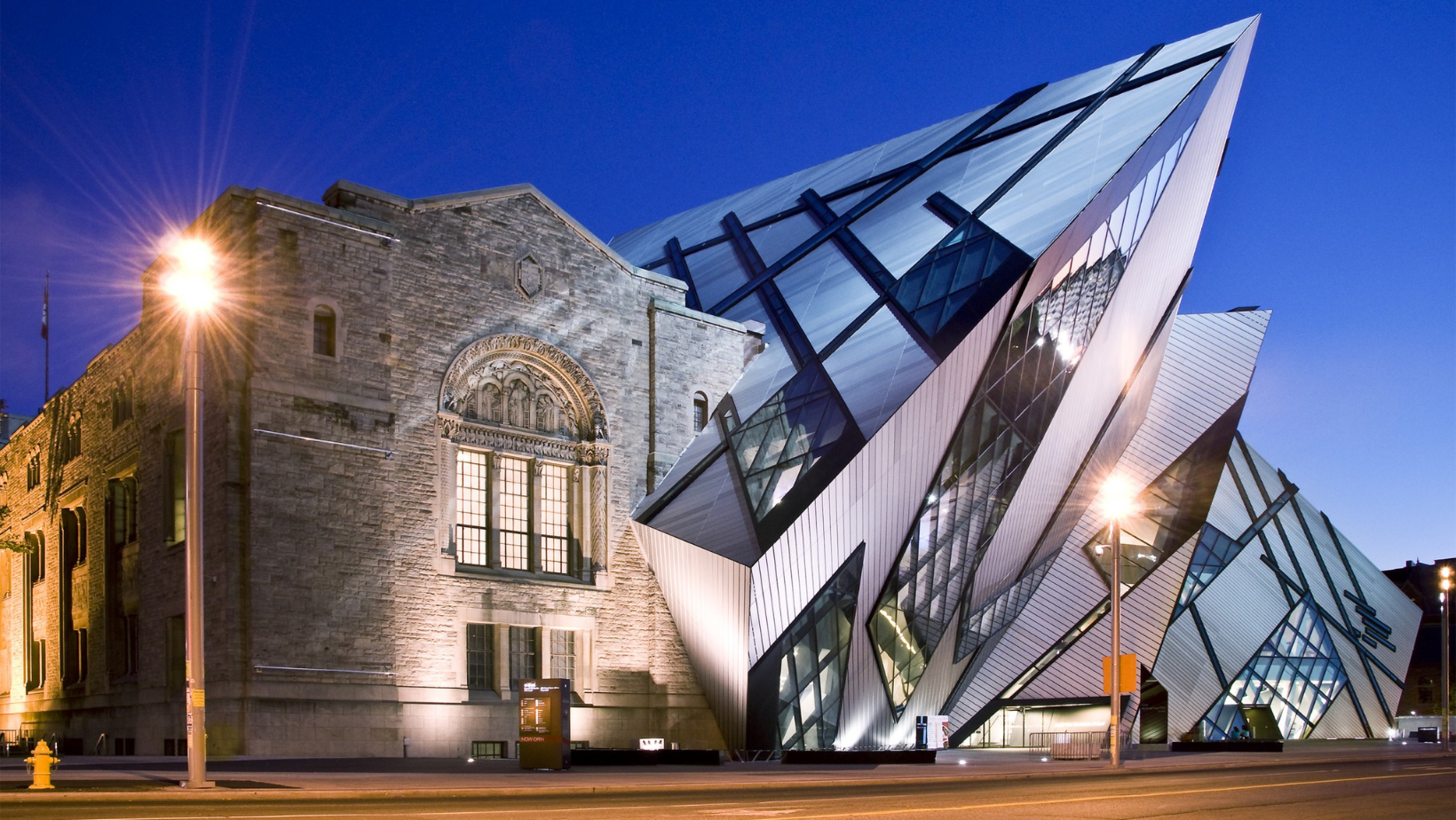 A evening picture of the front of the Royal Ontario Museum, showing the Michael Lee-Chin Crystal.