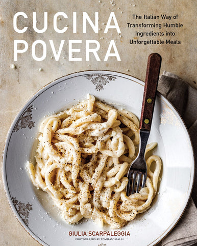 Cover of Cucina Povera featuring a white plate with long pasta noodles on a wooden table.