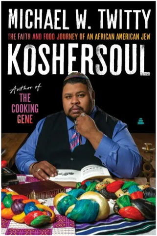 Michael Twitty, the author, sitting at a table with challah braided and dyed with colors in the many forms on his identity.