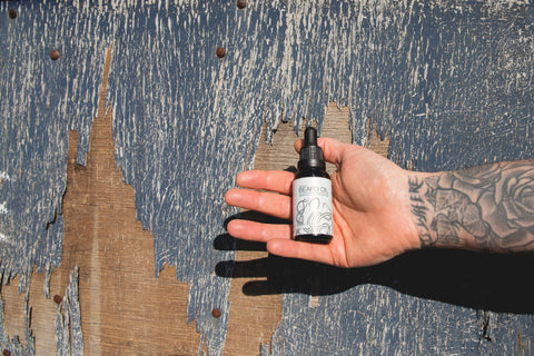 beard oil being held in the hand of a man