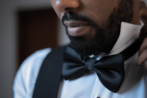 beautiful black man with a neat beard in tuxedo after applying beard oil