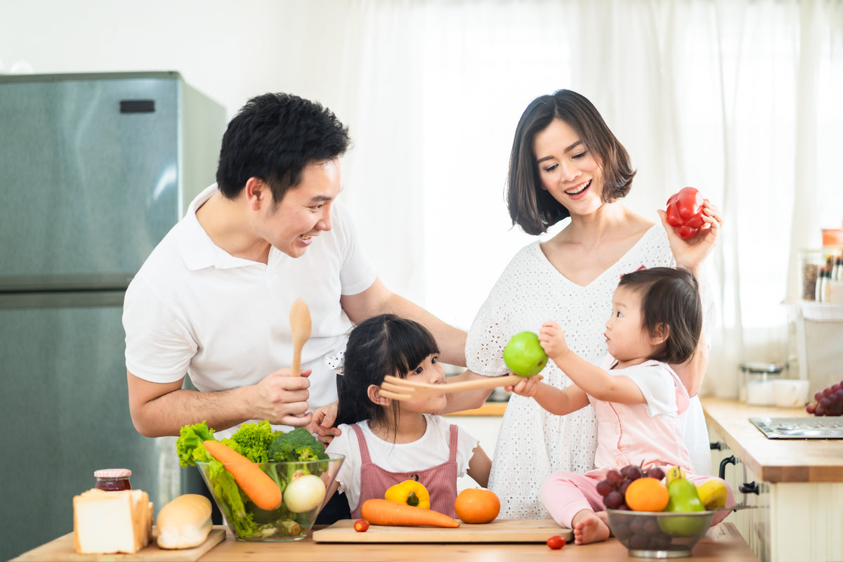 Мама папа продукт. Азиатская семья на кухне. Еда для маме и папе. Мама с папой застолье фото. Улыбающаяся мама с ребенком демонстрирующая упаковку витаминов.