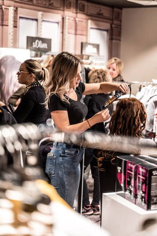 woman blow drying hair in a salon