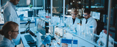 People in a lab wearing white coats and goggles making synthetic nicotine.  