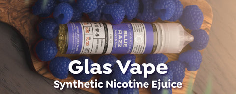 One bottle of Glas Vape Blue Raspberry Synthetic Nicotine Vape Juice on top of a handful of blue raspberries. 