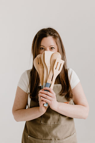 Wax Crescent founder, Kym Terribile, holding a bunch of spoons and making small batch non toxic luxury artisanal candles