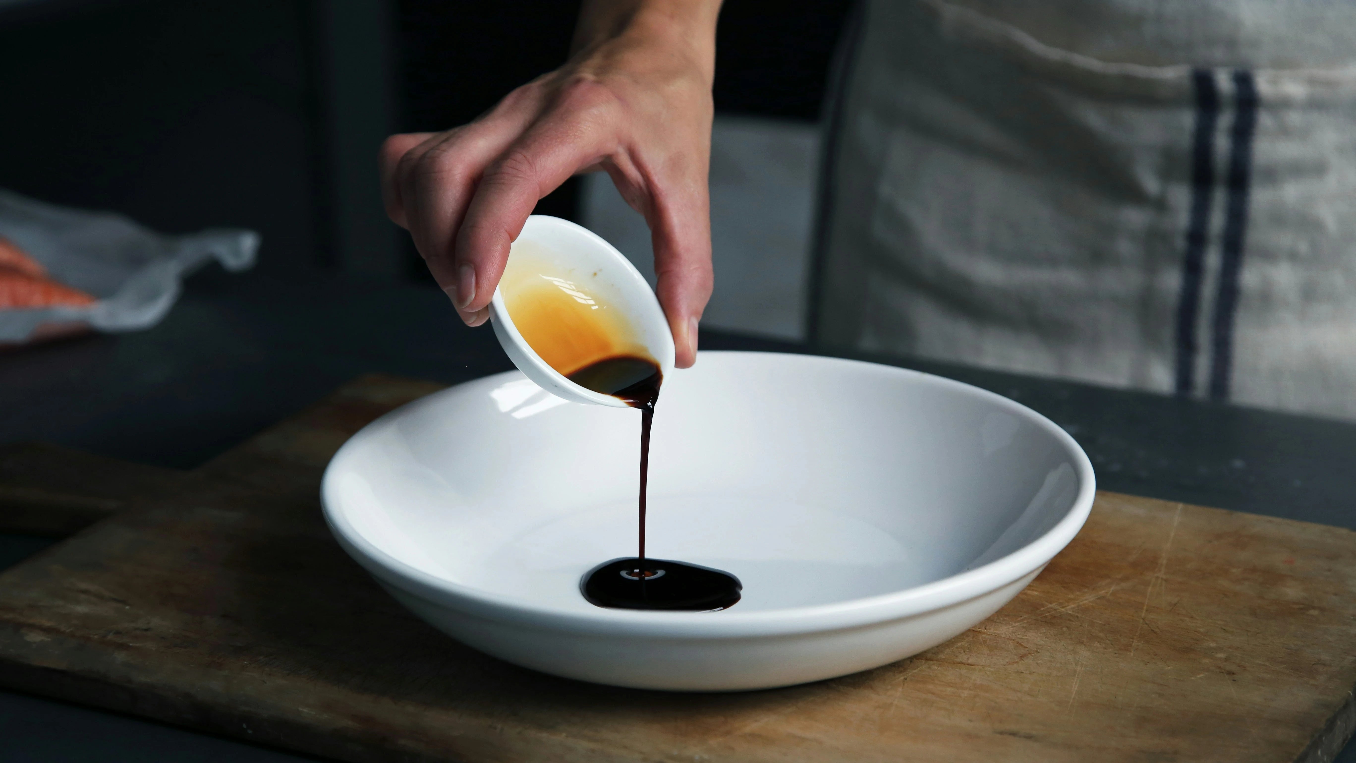 a chef pouring sauce on a plate, as featured in the SingleThread Wines blog on sake pairing, sake and unagi sauce