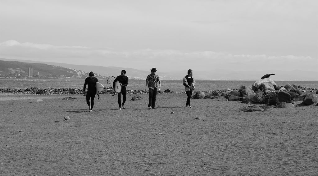 SURFERS IN WETSUIT PANTS AND TEES