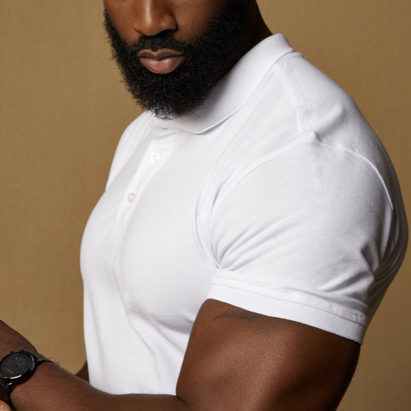 white tapered fit polo shirt showing the fit around the biceps