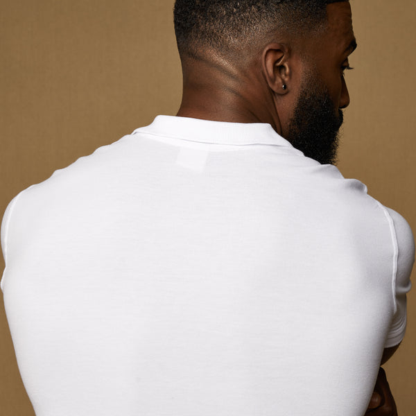 white tapered fit polo shirt showing the stretch around the back and shoulders