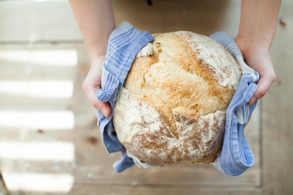 Frisch gebackener Brotlaib in den Händen