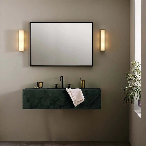 Warm wall lights on either side of the bathroom mirror