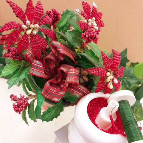 esempio come creare fiori stella di Natale perline con infilata conteria rocailles perle rosse su filo di ferro verde molinello infilaperle yoyo trottolina