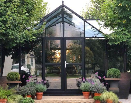 A beautifully maintained glass greenhouse entrance
