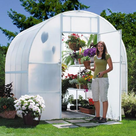 A woman standing outside her Solexx greenhouse