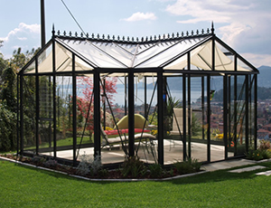 A glass greenhouse with a black frame