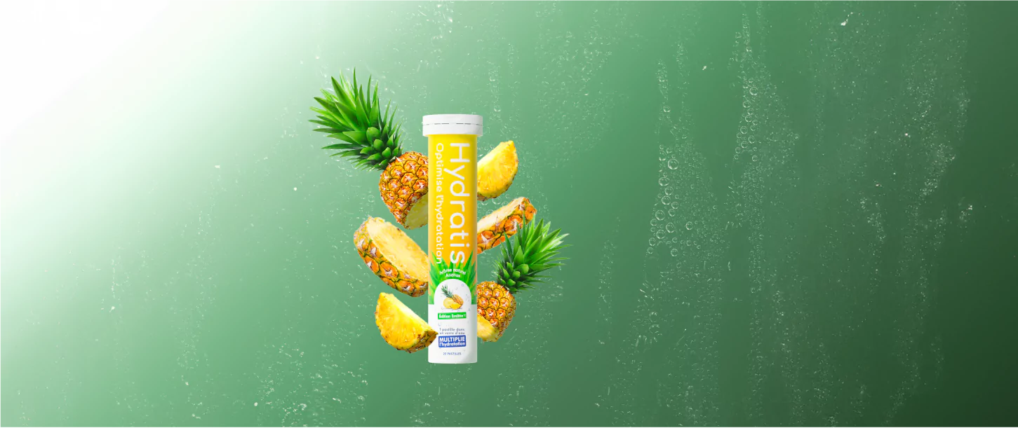 Effervescent hydration supplement with pineapple pieces and leaves on a green background.