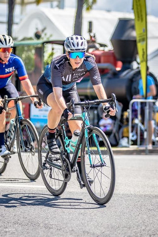 female cyclist with endometriosis racing a criterium in cairns australia