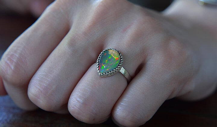 Opal gemstone ring in finger