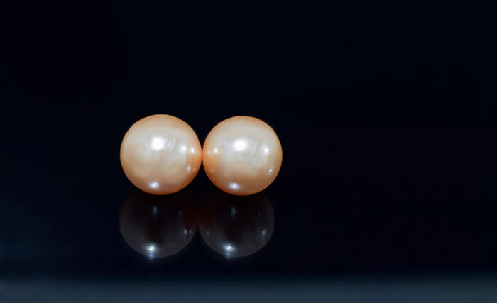 Gently stroke a pair of pearls together