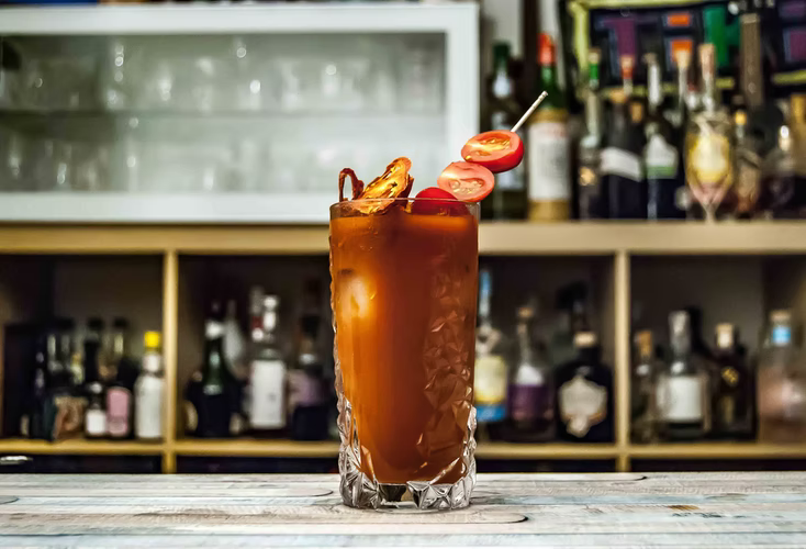 A classic Bloody Mary cocktail in front of a bar setup