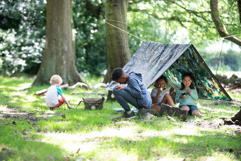 Children play into the woods with dens and nature