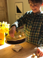 Child making simnel cake putting on marzipan balls