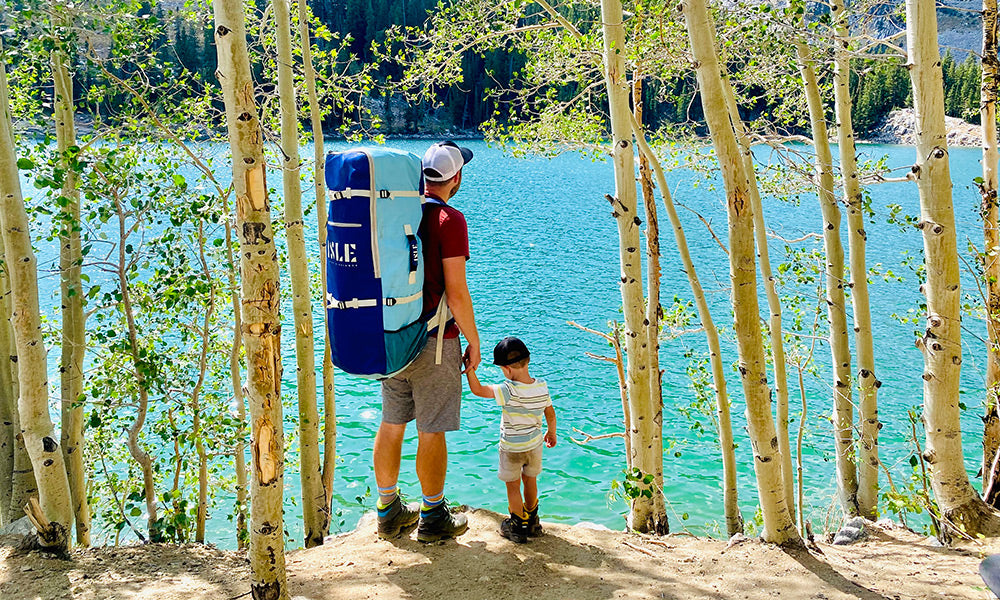 Dad and child holding hands looking out onto lake