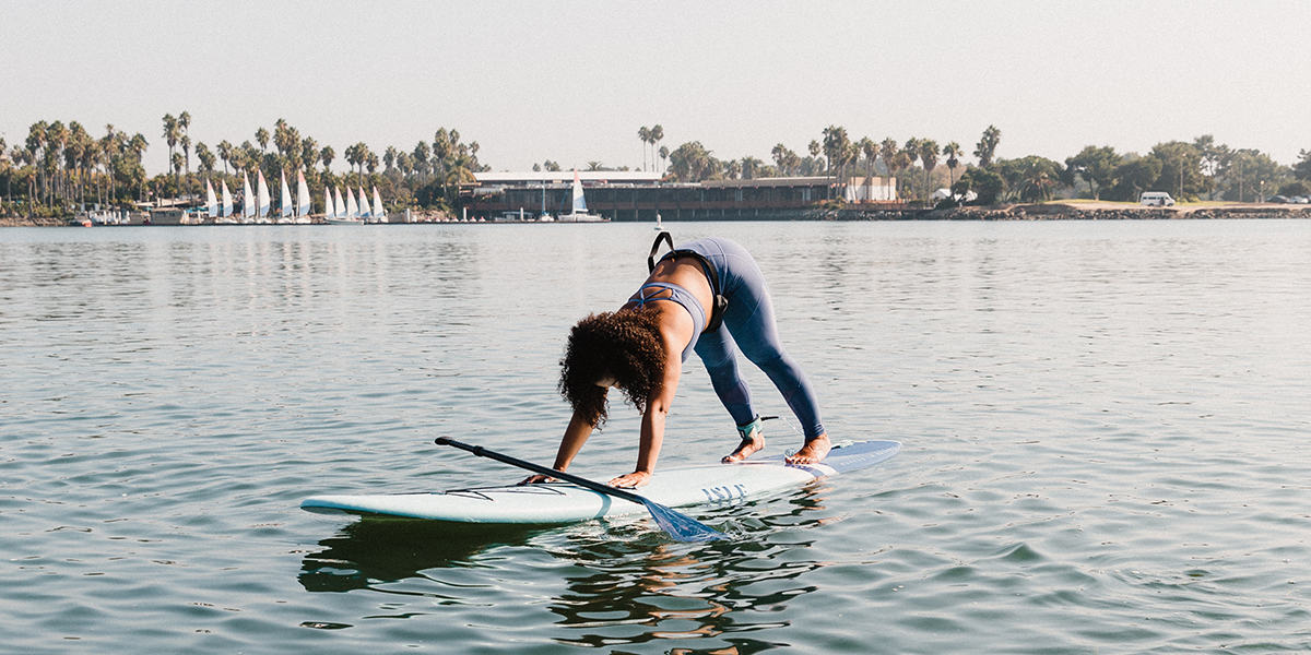 woman doing paddle board yoga