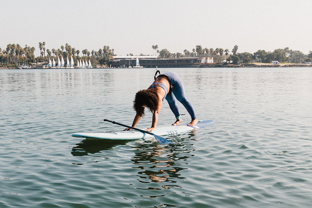 Woman doing down dog yoga on paddle board