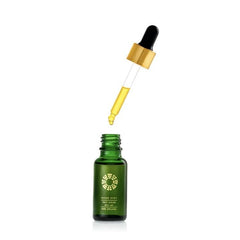 Small green bottle of face serum with pipet dripper suspended above bottle
