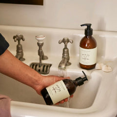 Hand holding a bottle of wild fig and saffron soap for sustainable self-care