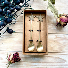 Star Christmas spoons in brass with flowers on wood as eco-friendly Christmas present