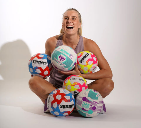 Maddy Turner with a bunch of her SUMMIT Sport designed netballs 