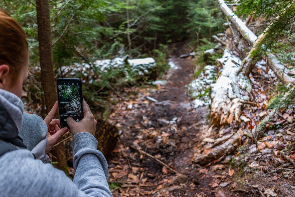 a woman photographing a trail 