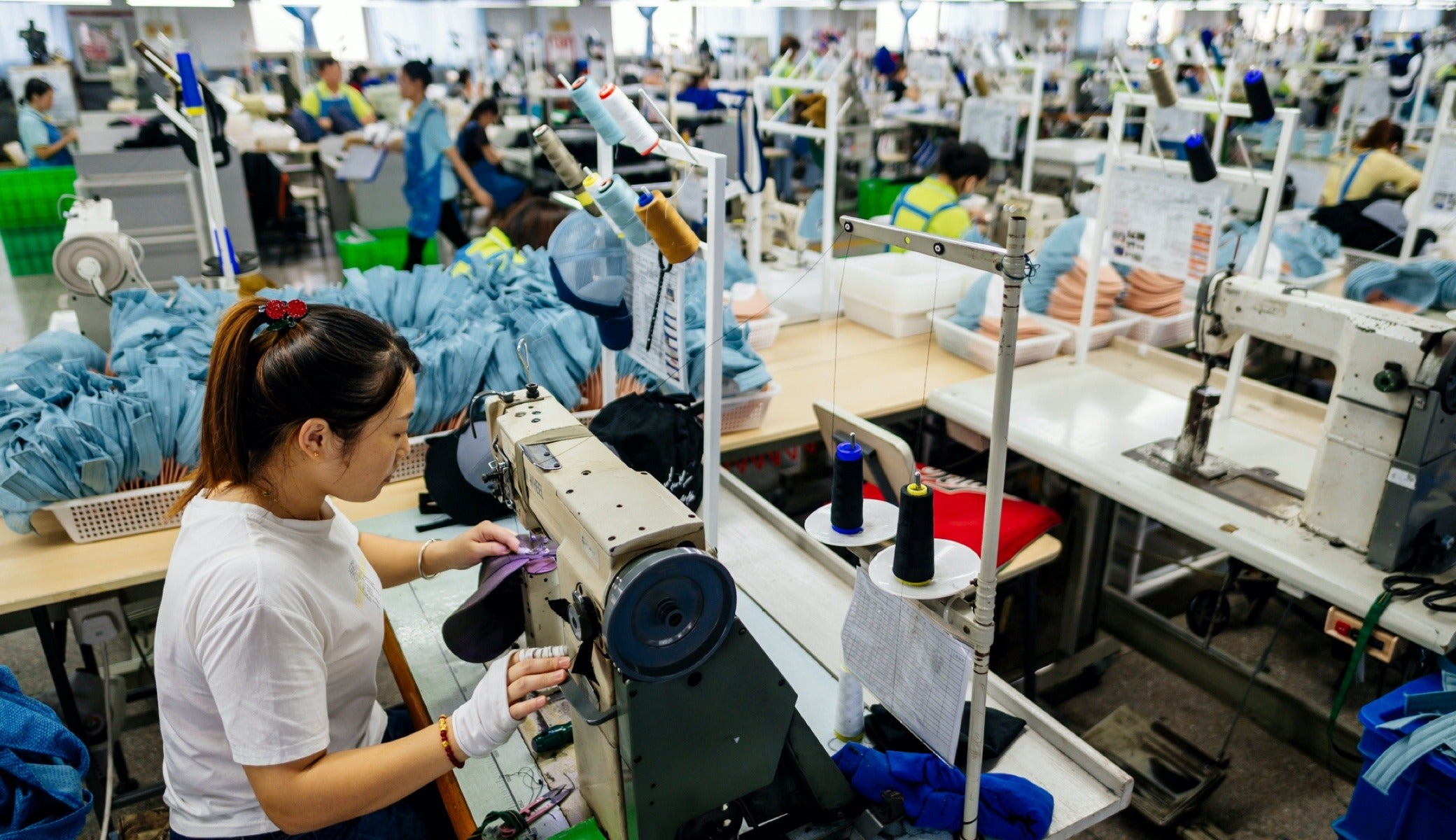 Qian Qian Wei sews on the factory floor at ASI in Shanghai.