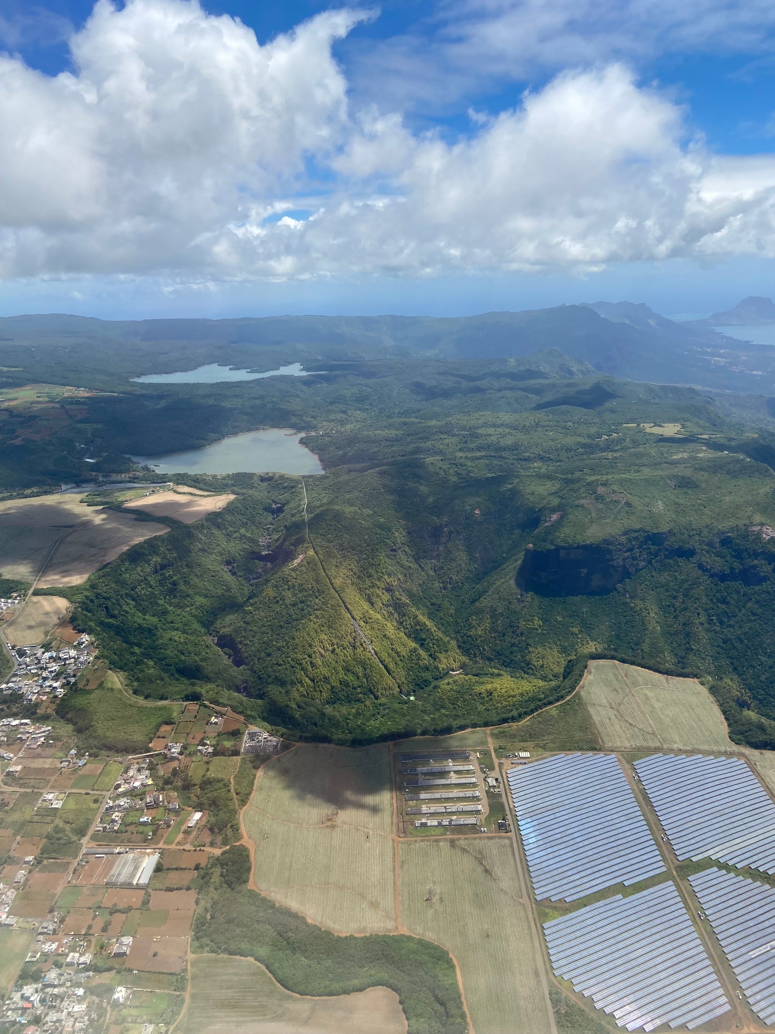 View from above of mountains in Mauritius with solar farm and water station 